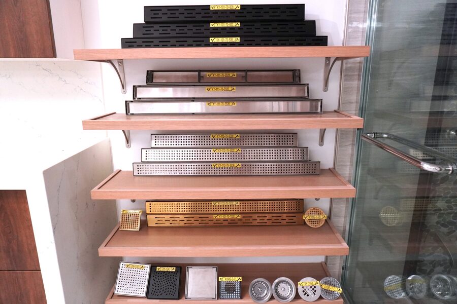 Linear and square shower drains in matte black, stainless steel and brushed gold at Golden Cabinets & Stone, Honolulu